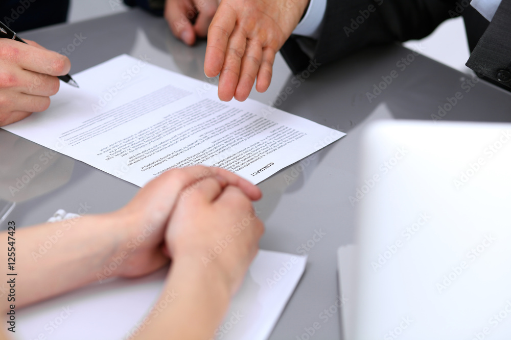 Business people discussing contract. Close up of male hand pointing to the paper Business people discussing contract. Close up of male hand pointing to the paper