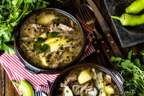 Traditional chilean latinamerican meat soup ajiaco served in clay plate photo