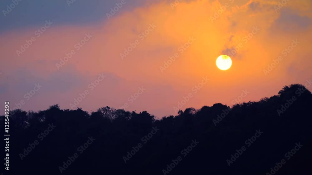 Golden sun setting above the jungle with beautiful colors of clouds around Golden sun setting above the jungle with beautiful colors of clouds around