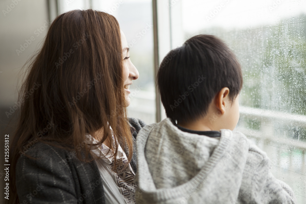 Mother and son are watching the rain Mother and son are watching the rain