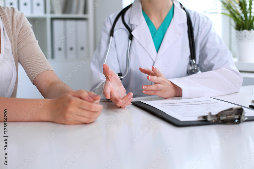 Doctor and patient are discussing something, just hands at the table Doctor and patient are discussing something, just hands at the table
