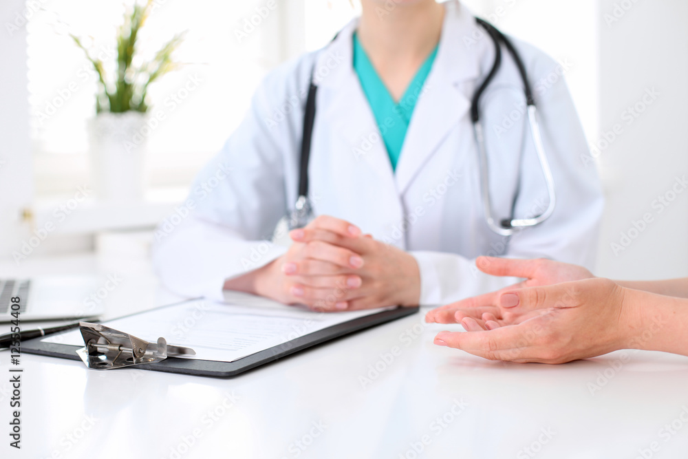 Doctor and patient are discussing something, just hands at the table Doctor and patient are discussing something, just hands at the table