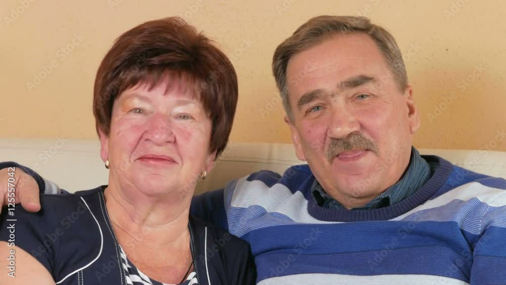 Happy senior man and woman making video call at home with the children. They are looking at the camera. Husband and wife in a beautiful house Happy senior man and woman making video call at home with the children. They are looking at the camera. Husband and wife in a beautiful house