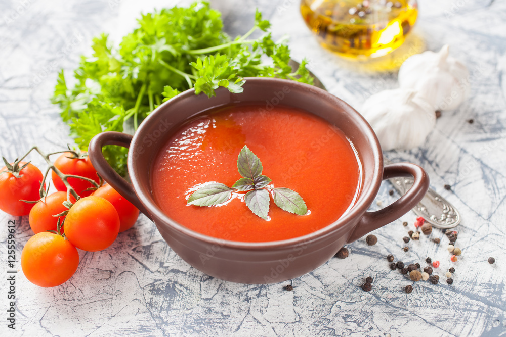 tomato soup with a basil in a bowl on a table, selective focus tomato soup with a basil in a bowl on a table, selective focus