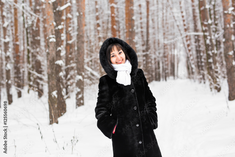 Woman in warm coat with fur in the forest, cold winter day Woman in warm coat with fur in the forest, cold winter day