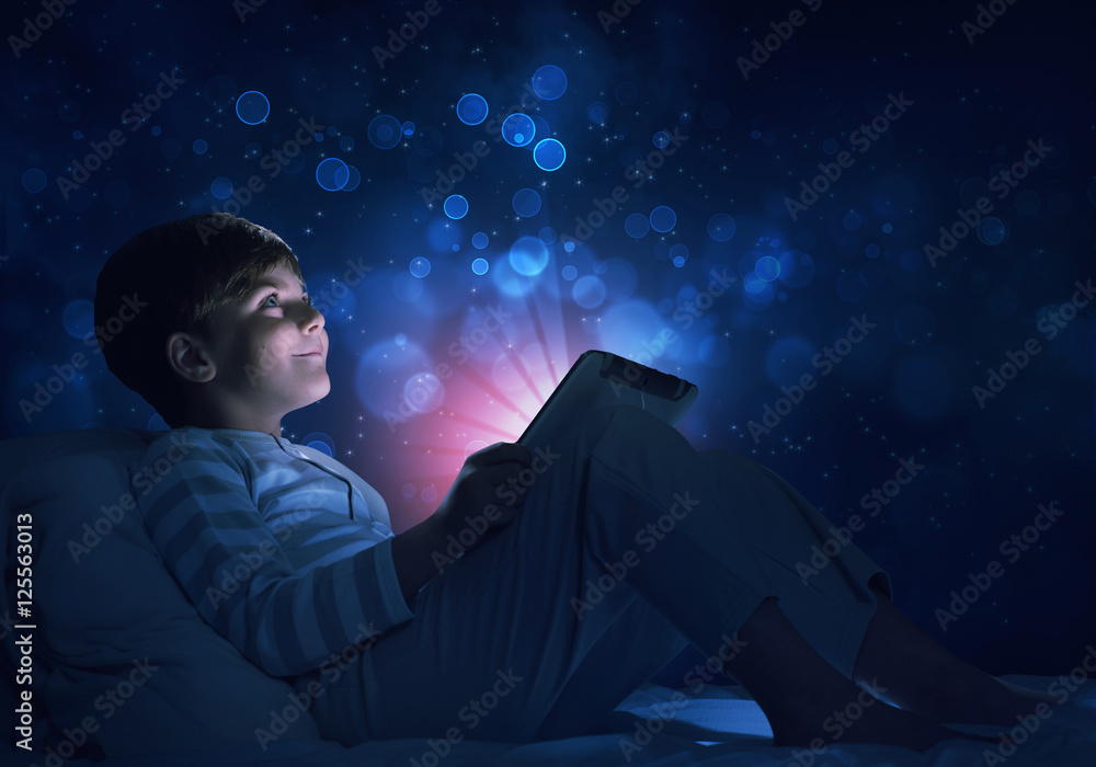 Fototapeta premium Boy with tablet in his bed