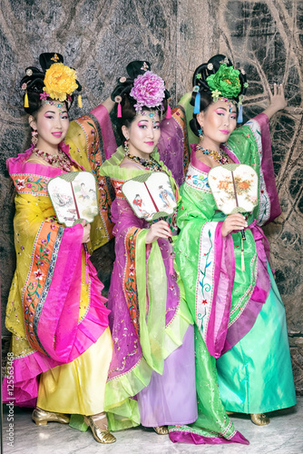 Three women in old traditional chinese dresses with fans