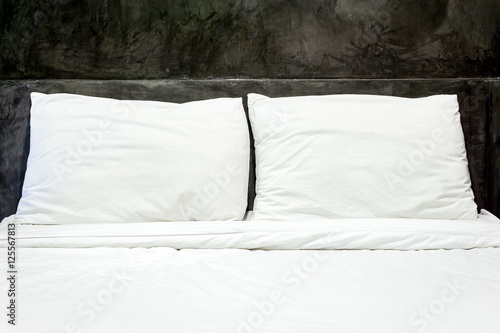 White pillows on a bed and bedding sheets on the bed