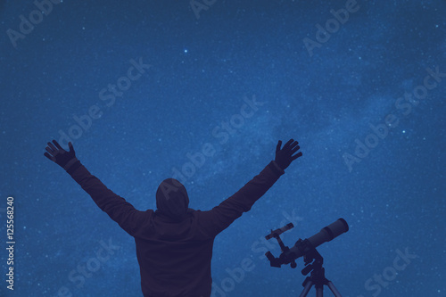 Wallpaper Mural Man enjoying under the starry sky with telescope beside him. Torontodigital.ca