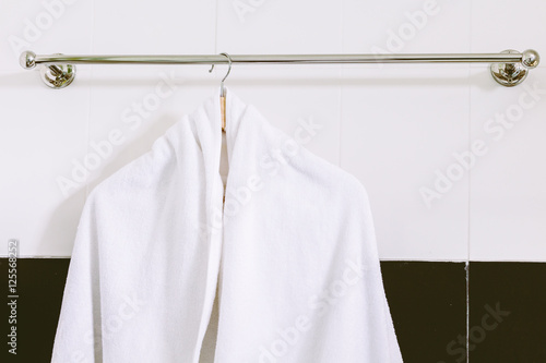 White towel on stainless steel towel hanger on wall in bathroom