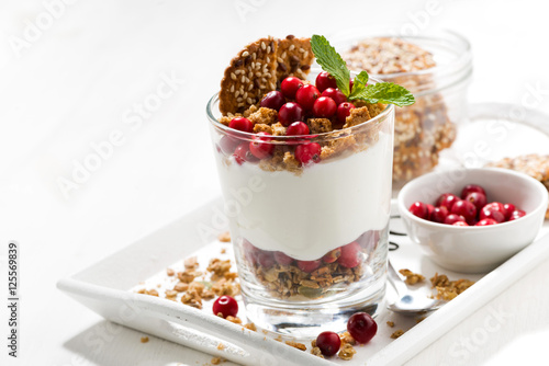 dessert with granola  cranberries and cream in glass