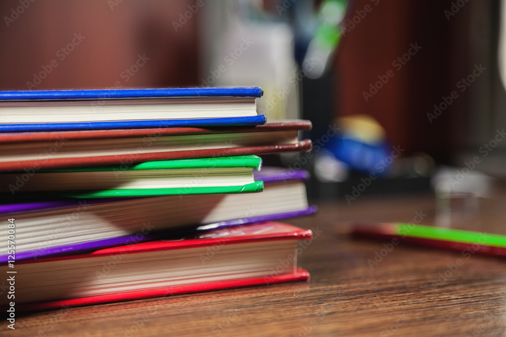 Different color books on dark wooden table Different color books on dark wooden table
