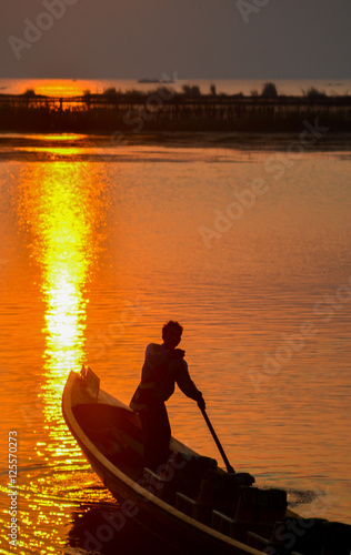 Boat in the bay on the background of a bright sunset sky © Nuthasak