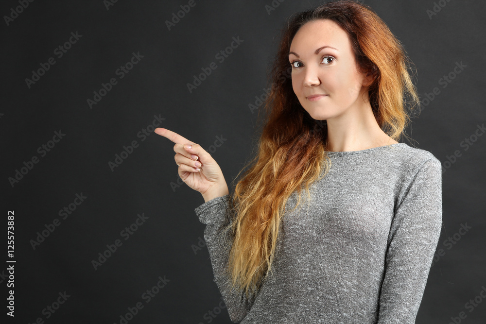 Pretty red-haired girl points a finger Pretty red-haired girl points a finger