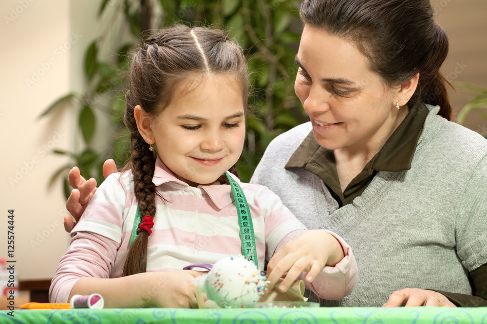 Fototapeta premium Little girl and mother sewing
