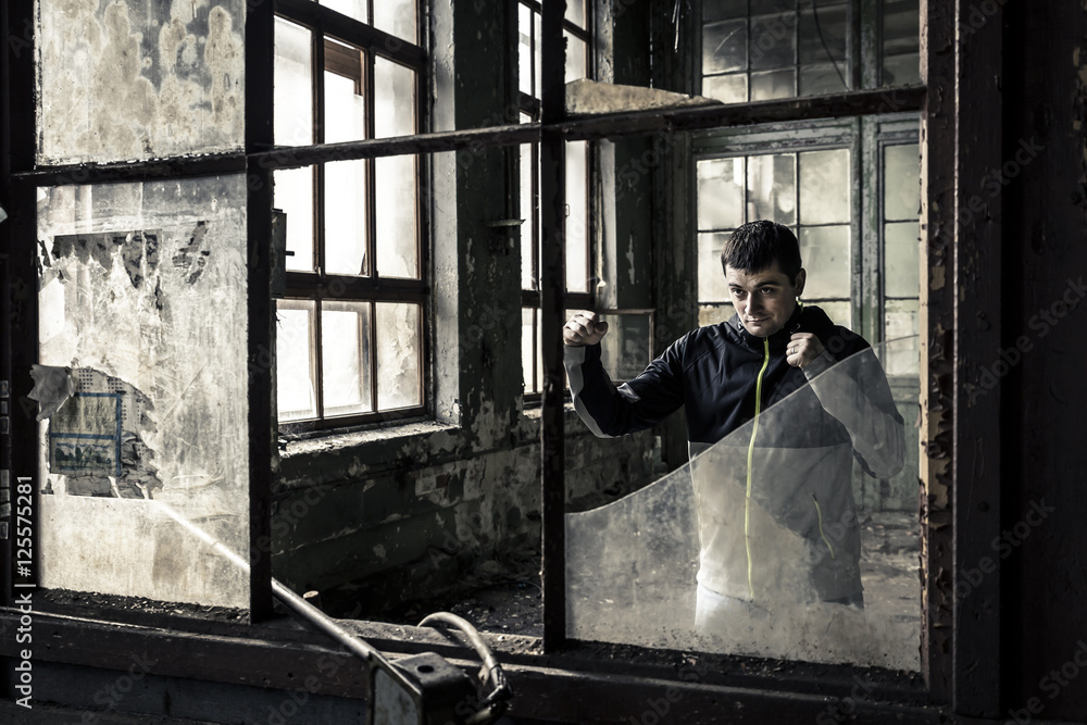 Young and serious man in the old, ruined factory Young and serious man in the old, ruined factory