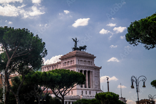 museum roofs behind a tree and under clouds