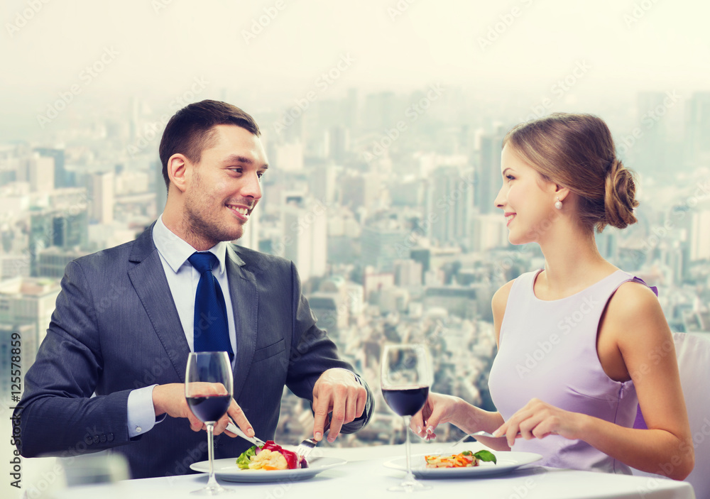 smiling couple eating main course at restaurant smiling couple eating main course at restaurant