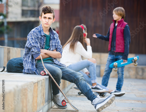 teen and his friends after conflict outdoors photo