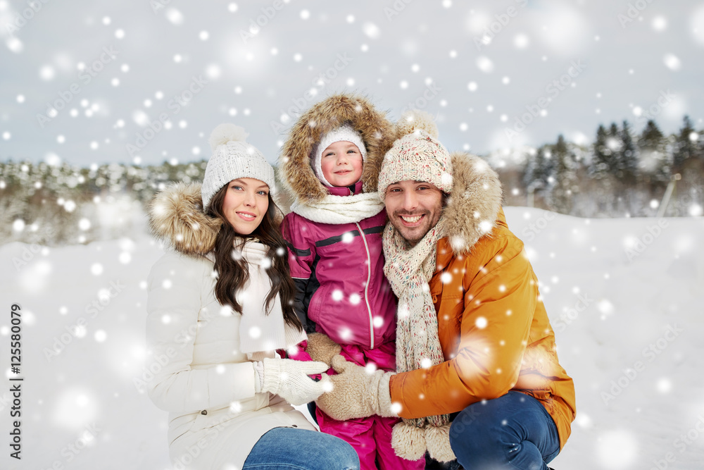 happy family with child in winter clothes outdoors