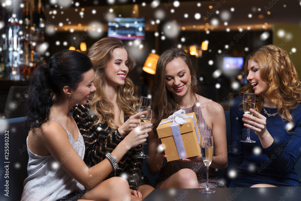 happy women with champagne and gift at night club happy women with champagne and gift at night club