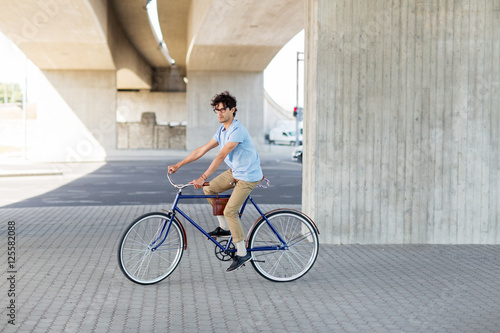 young hipster man riding fixed gear bike