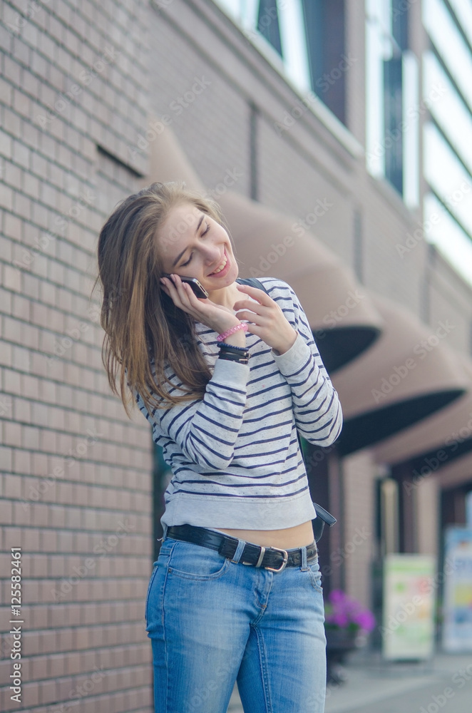 Fototapeta premium Young woman using her phone