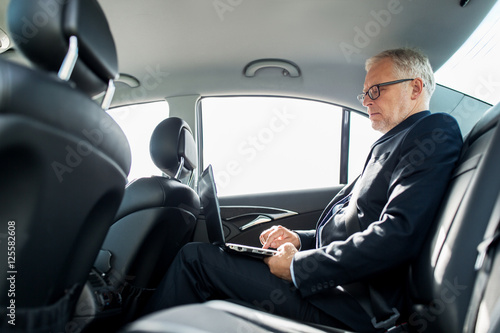 senior businessman with laptop driving in car © Syda Productions
