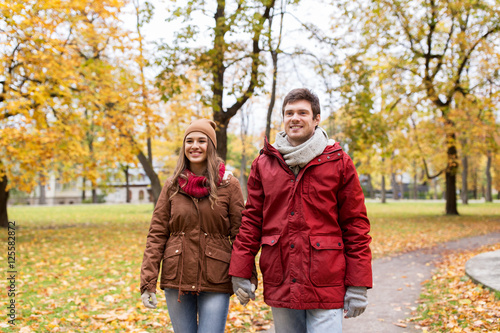 happy young couple walking in autumn park