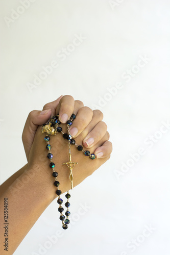 Hands of a asian woman Praying with Rosary isolated background