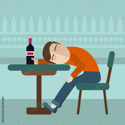 Drunk man sitting fall asleep on the table with a bottle of beer inside the pub. Over drink concept.