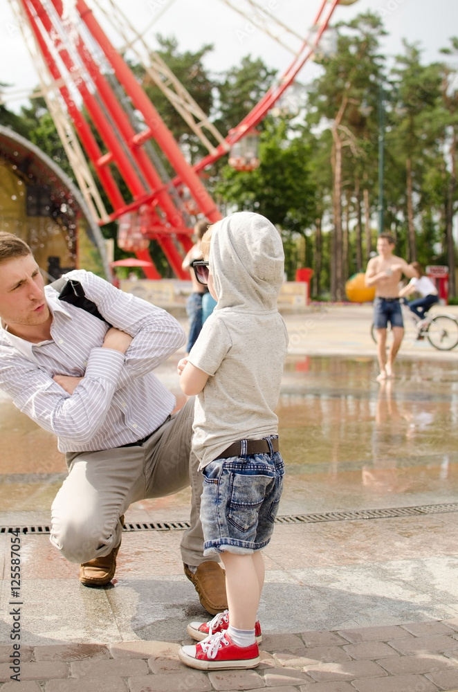 baby boy is walking in the park with his father