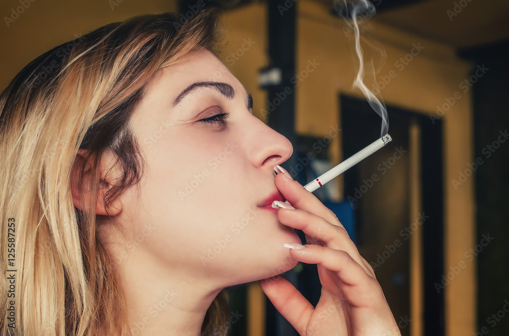 Fototapeta premium Beautiful girl pensive with her cigarette