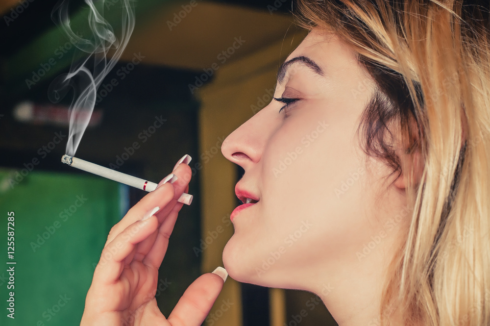 Fototapeta premium Beautiful girl pensive with her cigarette