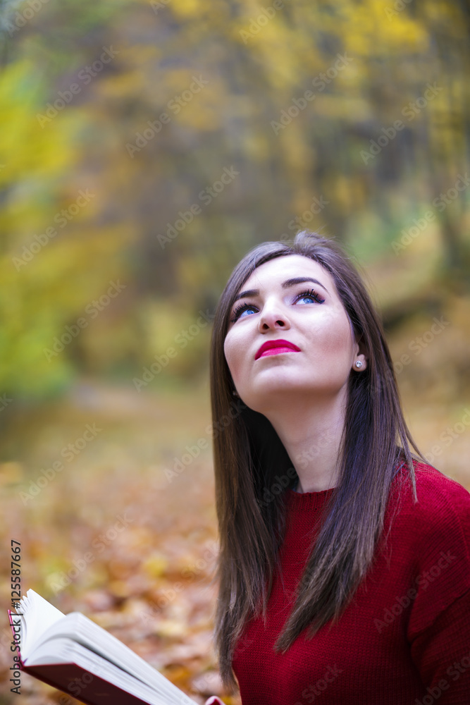 Portrait of beautiful young brunette girl reading a book in the Portrait of beautiful young brunette girl reading a book in the