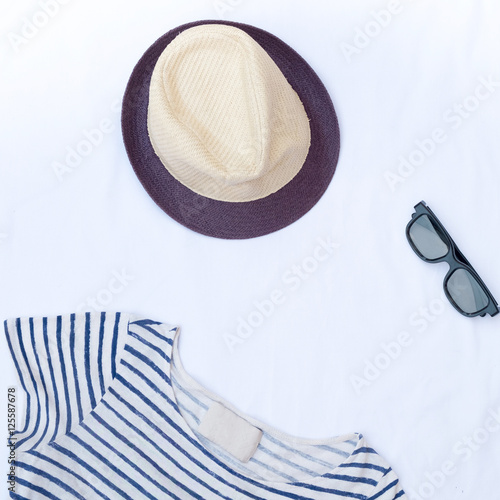 flat lay feminini clothes and accessories and hat on white backg photo