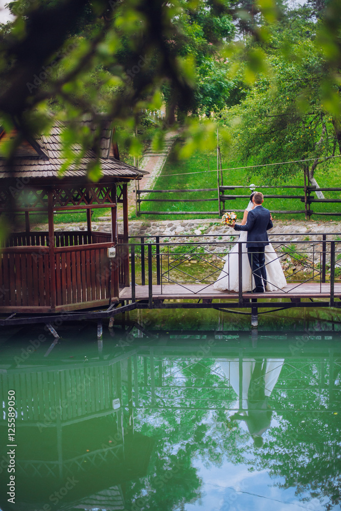 Obraz premium Groom and Bride in a park. wedding dress. Bridal wedding bouquet of flowers. Newlyweds on nature.