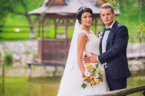 Wedding couple, bride, groom posing embacing on pier photo