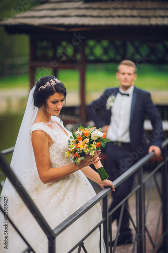 Wedding couple, bride, groom posing embacing on pier photo