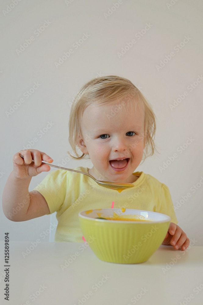 Little baby girl eating pumpkin cream-soup Little baby girl eating pumpkin cream-soup
