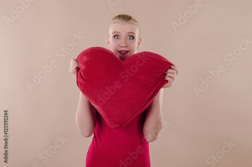 Beautiful young woman in a bright red slinky dress hugging a plu © Alona Dudaieva