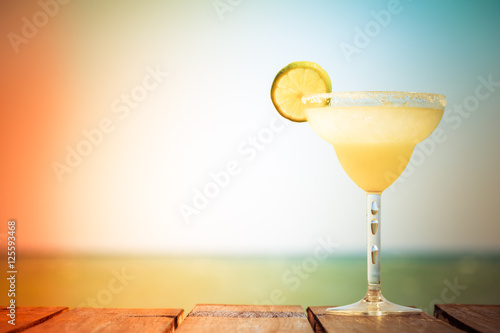 Sticker Margarita cocktail on the wooden pier. Concept of classic drink.