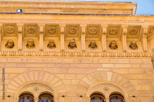 Siena, Italy. The sculptures of the Roman emperors on the facade of Spannokki Palace (XV c.) in Piazza Salimbeni Square photo