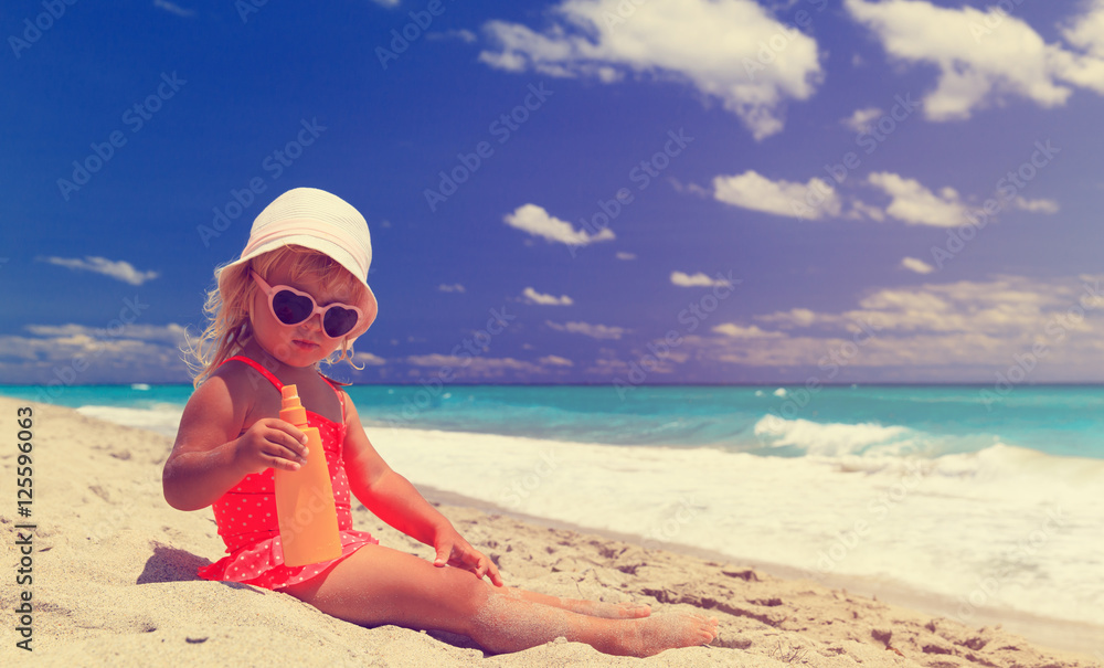 sun protection concept - little girl with suncream at beach sun protection concept - little girl with suncream at beach