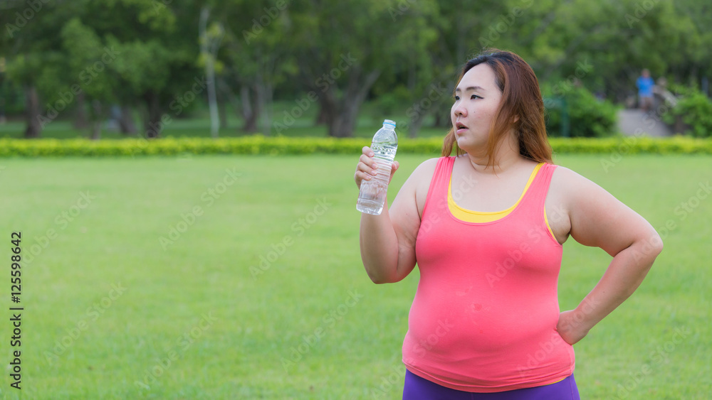 Beautiful fat woman drinking water after finish her workout. Beautiful fat woman drinking water after finish her workout.