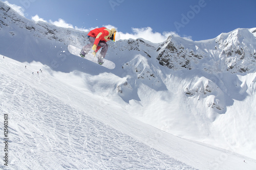 Snowboard rider jumping on mountains. Extreme snowboard sport.