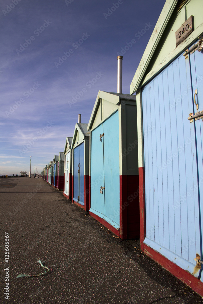 Long row of beach huts on Brighton seafront, Brighton, England,