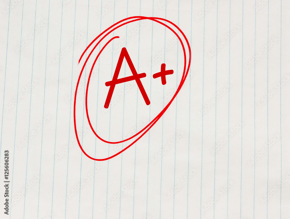A plus (A+) grade written in red on notebook paper A plus (A+) grade written in red on notebook paper