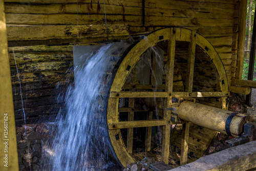 Canvas Print Working watermill wheel with falling water in the village in Voronezh Region