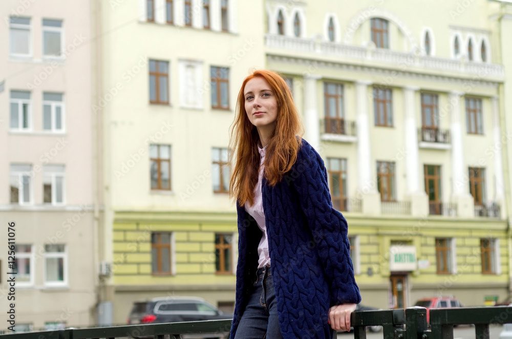Fototapeta premium Young red woman walking in the city